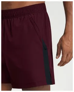 Macro detail view of men's quick-dry burgundy athletic shorts with side pocket