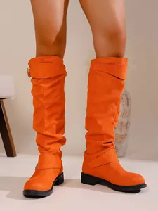 Detailansicht der orangefarbenen Wildleder-Stiefel mit Blockabsatz und Schnallen