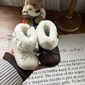 Detailansicht warmer, gefütterter Babystiefel mit dekorativen Schleifen und weichen Sohlen