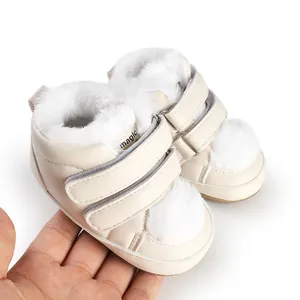 Detail view of cream baby walking shoes with white faux fur lining and velcro straps.