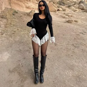 Close-up of slim-fit long sleeve bodysuit featuring delicate white lace trim detail
