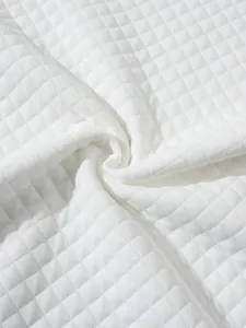 Gros plan montrant la texture matelassée douce du tissu gaufré blanc pour sweat-shirt