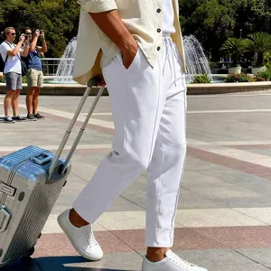 Dettaglio di pantaloni casual bianchi da uomo dal taglio dritto in un contesto di viaggio