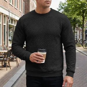 Homme en sweat à manches longues noir matelassé marchant avec un café en main