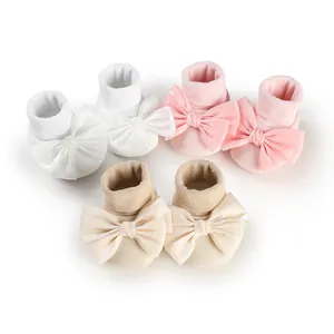 Set of three baby bowknot non-slip pre-walker floor socks in white, pink, and beige.