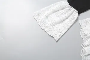 Close-up detail of elegant white floral lace flare sleeve on black long sleeve bodysuit