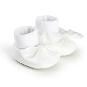 High-quality detailed view of soft white baby floor socks featuring elegant large satin bows