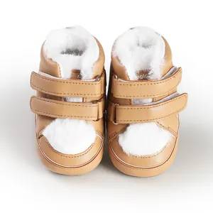 Close-up of tan baby walking shoes with soft white faux fur lining and velcro straps