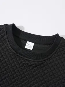 Détail en gros plan d'un sweat-shirt noir matelassé à texture gaufrée avec étiquette
