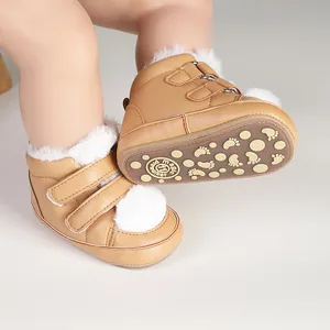 Close-up of tan baby pre-walker shoes with white fur trim and non-slip rubber sole
