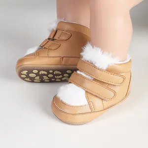 Close-up view of tan baby walking shoes featuring white faux fur trim and velcro straps.