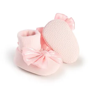 Detail of pink baby floor socks with satin bow and non-slip dotted sole
