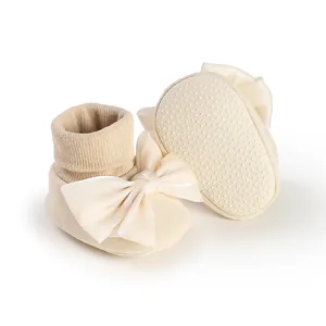 Close-up view of cream baby bow floor socks featuring the anti-slip dotted sole