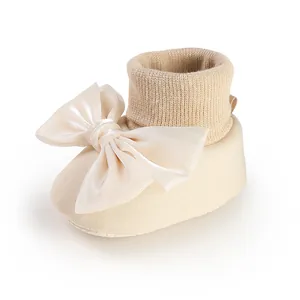 Close-up of baby floor sock with large satin bow and soft knit fabric