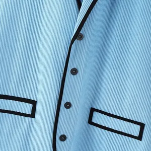 Detailaufnahme einer hellblauen Cordweste mit schwarzer Paspelierung und Knöpfen