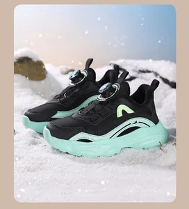 Close-up of children's running shoes with rotating dial lace system in a snow scene