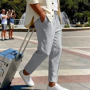 Vista lifestyle di pantaloni casual dritti grigi larghi da uomo con coulisse in vita