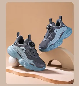 Detail of breathable girls' running shoes featuring a rotary buckle closure in blue and grey.