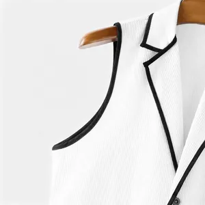 Detailaufnahme einer weißen Cordweste mit schwarzen Kontrastpaspeln und Revers.