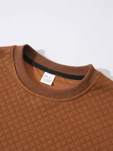 Gros plan sur le col d'un sweat-shirt matelassé marron avec étiquette de taille S blanc.