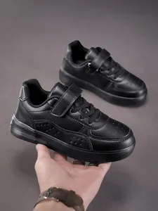 Detailed close-up view showing the durable black leather texture of kids low-top sneakers