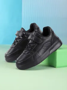 Close-up of black children's low-top sneakers with Velcro strap and laces.