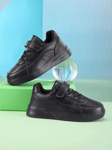 Close-up of black children's low-top sneakers with velcro strap and breathable upper