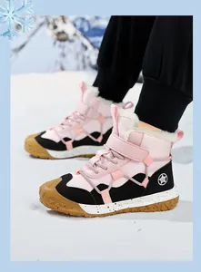 Nahaufnahme von rosa-schwarzen Kinder-Winterstiefeln mit warmem Fellfutter