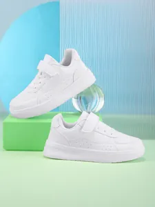 Clean white children's low-top sneakers featuring Velcro straps and perforated side details