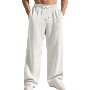 Dettaglio dei pantaloni sportivi bianchi a costine da uomo con vestibilità comoda.