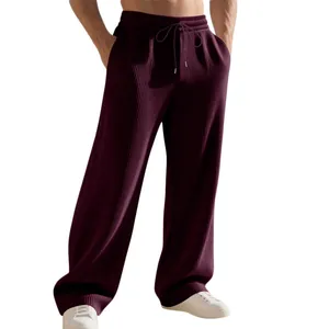 Dettaglio della pesante texture a costine dei pantaloni bordeaux da uomo a gamba larga.