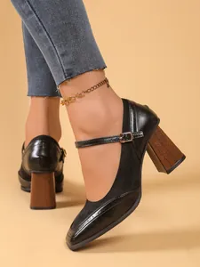 Primer plano de zapatos Mary Jane vintage negros con tacón ancho efecto madera y hebilla
