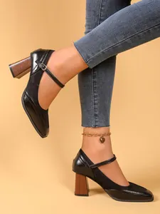 Vista detallada de zapatos Mary Jane negros con diseño patchwork y tacón grueso de madera vintage