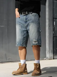 Detailed view of men's loose straight denim shorts with sparkling rhinestone accents