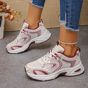 Side view of beige and burgundy chunky mesh dad sneakers with thick soles and lacing