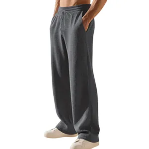 Dettaglio ravvicinato della trama in maglia a coste pesanti sui pantaloni grigi uomo
