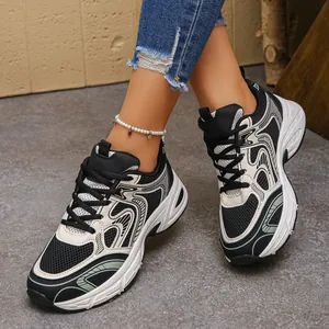 Detail view of chunky dad sneakers with mesh panels and thick sole worn with blue jeans