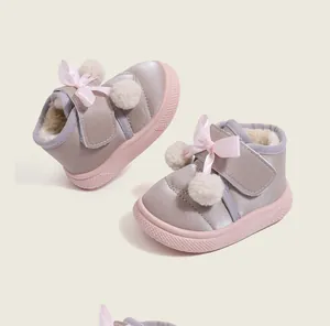 Warm fleece-lined winter toddler girl shoes featuring pink ribbon bows and soft pom-poms.