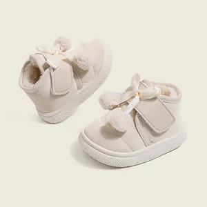Cozy winter toddler shoes featuring a cute ribbon bow, soft pom-poms, and warm velvet lining.