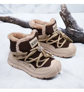 Children's warm snow boots with faux fur lining and drawstring laces on snow background