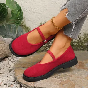 Detail view of stylish red suede Mary Jane shoes featuring a round toe and strap