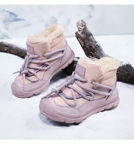Detailed view of pink kids' snow boots with warm fur lining in a snow setting