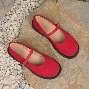 Red suede French style Mary Jane shoes with round toe and buckle strap on natural stone