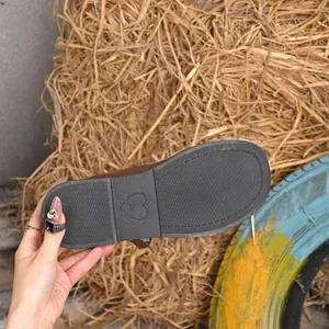 Detail view of the black heart-patterned outsole of a brown suede Mary Jane shoe