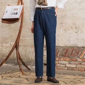 Klassische dunkelblaue Jeans für Herren im geraden Schnitt in rustikaler Umgebung.