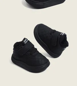 Detail of black quilted baby winter boots with warm fleece lining and Velcro strap.