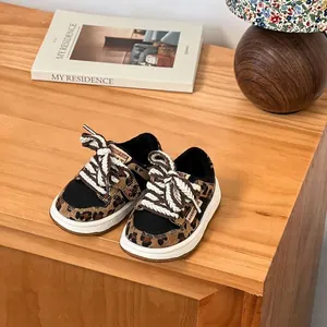 Gros plan de baskets léopard pour enfants avec lacets tressés épais et doublure en peluche.