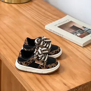 Détail rapproché de baskets pour enfants léopard avec lacets épais en tissu tressé.