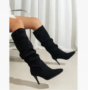 Elegante Detailansicht schwarzer Stiletto-Stiefel mit spitzer Kappe und Falten-Design.