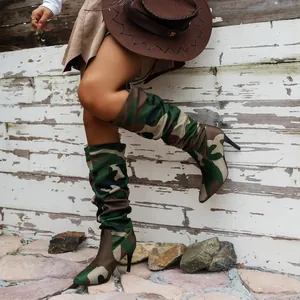Trendige Camouflage-Stiefel mit spitzer Kappe und Pfennigabsatz in ländlicher Kulisse.